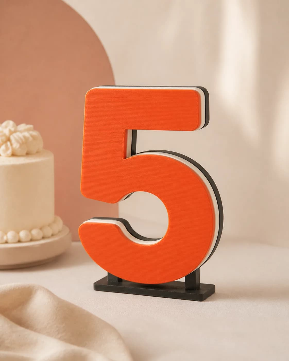 Freestanding orange number five with a layered edge and weighted base